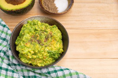 Ev yapımı avokado, limon, tuz ve biber için malzemelerle dolu bir tabakta taze guacamole. Üst Manzara. Geleneksel Meksika hazırlığı kavramı.
