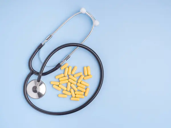 Bovenaanzicht Van Gele Capsule Pillen Stethoscoop Een Lichtblauwe Achtergrond Ruimte — Stockfoto