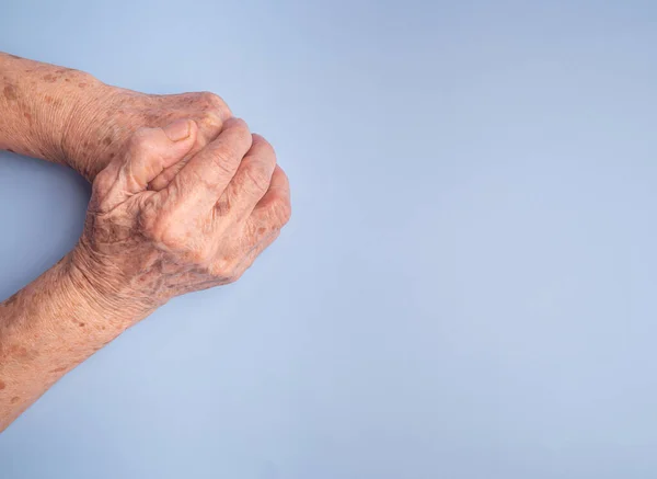 Close Das Mãos Mulher Sênior Uniram Para Orar Fundo Azul — Fotografia de Stock