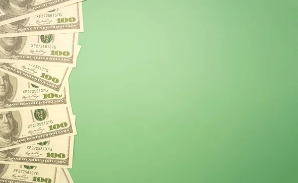 100 dolarlık banknotların üst görüntüsü izole edilmiş yeşil bir zemin oluşturuyordu. Düz yatıyordu. Mesaj için yer var. Amerikan para birimi, iş ve finans kavramı.