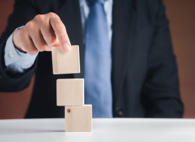 Boş tahta blokları düzenleyen iş adamının eli. Yakın plan fotoğraf. Mesaj için yer var. İş ve strateji planlama kavramı.