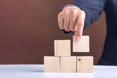 Boş tahta blokları düzenleyen iş adamının eli. Yakın plan fotoğraf. Mesaj için yer var. İş ve strateji planlama kavramı.