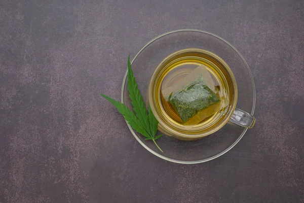 A cup of hemp tea laid on vintage background. Cannabis herbal tea. Close-up photo. Space for text. Relaxation concept.
