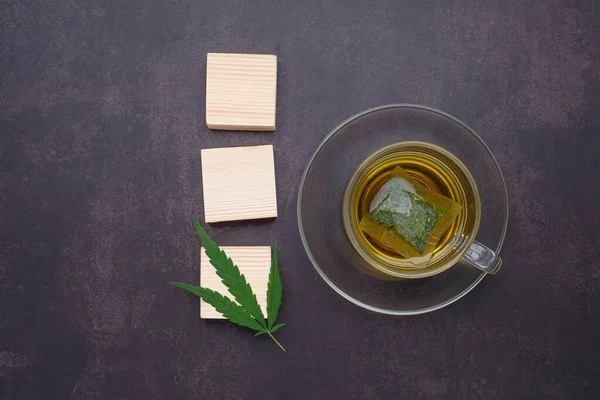 A cup of hemp tea laid on vintage background. Cannabis herbal tea. Close-up photo. Top view. Flat lay. Space for text. Relaxation concept.