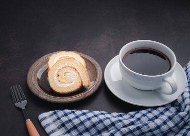 Beyaz bir kahve fincanı, tepside krep ve mutfaktaki eski masanın üzerine bir bez. Mesaj için yer var. Rahatlama kavramı.