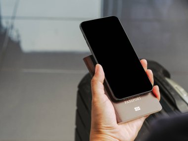 Bavul geçmişi olan bir akıllı telefonun el ele tutuşması. Yakın plan fotoğraf. Mesaj için yer var. Teknoloji ve iletişim konsepti.