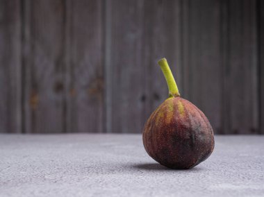 Olgun incir meyvesi, ahşap duvarlı beton zeminde. Yüksek vitamin meyvesi. Mesaj için yer var. Sağlıklı meyve ve sağlık hizmeti kavramı.