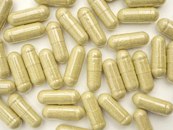 Full frame of Andrographis capsules isolated on a white background. Close-up photo. Space for text. Herbal, medicine, and healthcare concept.