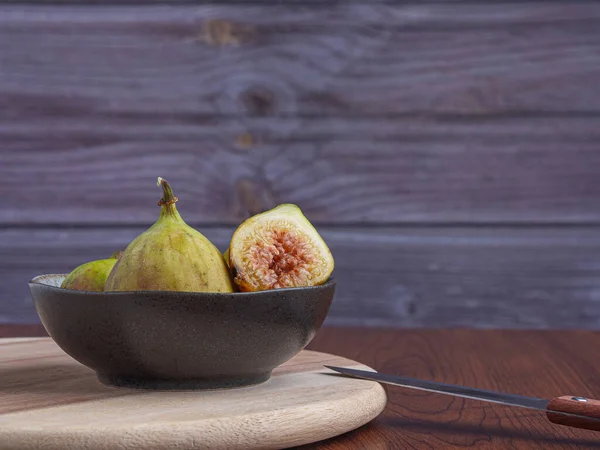 Ripe figs fruit on the cement floor with a wooden wall background. High Vitamins fruit. Space for text. Healthy fruits and healthcare concept.