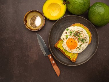 Avokado ve yumurtalı tost tabakta servis edilir. Üst Manzara. Metin için boşluk.