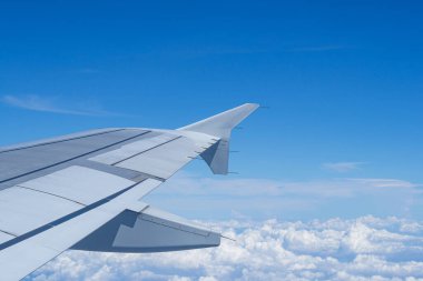 Bulutların ve gökyüzünün hava görüntüsü bir uçağın penceresinden görüldüğü gibi..