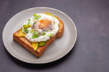 Avokado ve yumurtalı tost klasik arka planda servis edilir. Üst Manzara. Metin için boşluk.