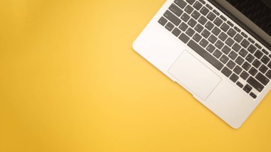 Sarı arka planda izole edilmiş, metin için alanı olan bir dizüstü bilgisayarın üst görüntüsü. Bilgisayar ve teknoloji kavramı.