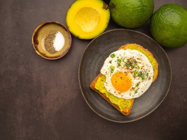 Avokado ve yumurtalı tost tabakta servis edilir. Üst Manzara. Metin için boşluk.