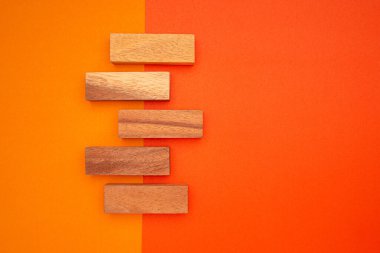 Turuncu ve kırmızı arka planda izole edilmiş beş boş tahta bloğun üst görüntüsü. Metin için boşluk