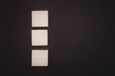 Siyah zemin üzerinde boş üç ahşap küp görünümü metin için boşluk ile