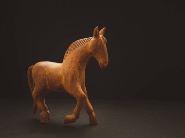 Siyah arka planda yaşlı bir tahta at var. Klasik el yapımı. Metin için boşluk