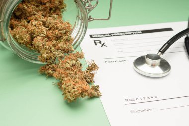 Tıbbi reçete kağıdında steteskop ve yeşil arka planda kuru marihuana tomurcukları. Mesaj için yer var. Bitkisel, tıbbi ve sağlık hizmetleri kavramı