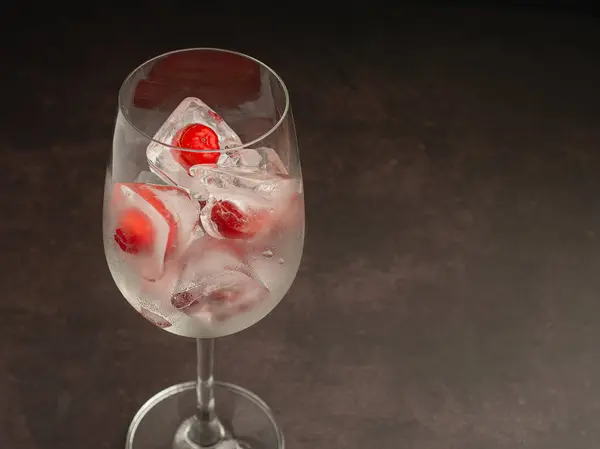 stock image Wine glass with a fresh cherry on ice. Refreshing cold drink. Summer party. High vitamin C fruits. Healthy fruit concept