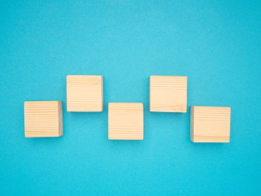 Mavi arkaplan üzerinde boş beş tahta küpün üst görünümü metin için boşluk ile