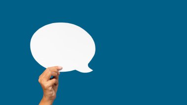 Mavi arka planda boş bir beyaz konuşma balonunun el ele tutuşması. Konuşma balonu konsepti. Mesaj için yer var. Yakın plan fotoğraf.