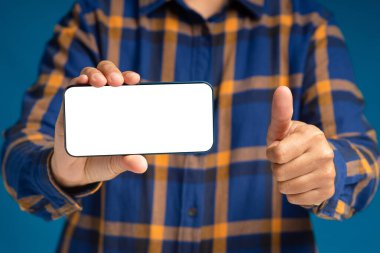 Akıllı telefonu tutan ve baş parmağını kaldıran bir el resmi. Müşteri memnuniyeti için en iyi hizmet beş yıldızlı not veriyor. Müşteri geribildirimi, hizmet değerlendirmesi ve memnuniyeti