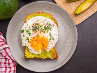 Avokado ve yumurtalı tost tabakta servis edilir. Üst Manzara. Mesaj için yer var. Yüksek vitamin meyvesi. Sağlıklı meyve kavramı