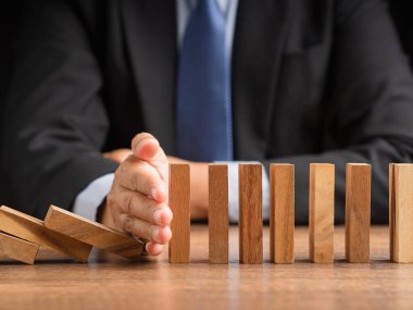 İş dünyası çökmeden önce domino işi krizini durduran iş adamlarının yakın çekimi. Risk yönetimi ve İş Krizi yönetim kavramı