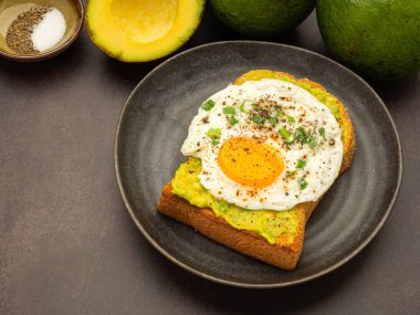 Tahta kesme tahtasının üzerinde avokado ve yumurtalı tost. Üst Manzara. Mesaj için yer var. Yüksek vitamin meyvesi. Sağlıklı meyve kavramı