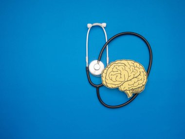 Stetoskop ve mavi arka planda kağıttan yapılmış beyin şekli. Alzheimer, Parkinson hastalığı, bunama, felç, nöbet ya da akıl sağlığı. Nöroloji ve Psikoloji