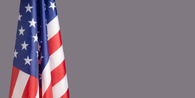 Amerikan bayrağının yakın çekimi sol tarafta gri bir arka planda metin için fotokopi alanı var. 4 Temmuz. Amerikan Ulusal Günü 'nü kutlayın. İşçi Bayramı. Bağımsızlık Günü. Anma Günü