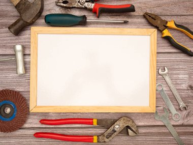 Boş bir beyaz tahta ve inşaat aletleri, çekiç, tornavida, vida ve pense. Üst Manzara. Metin için boşluk