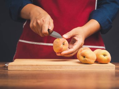 Şef mutfakta dururken olgun şeftali dilimliyor. Sağlıklı meyve ve yiyecek kavramı. Yakın plan fotoğraf.