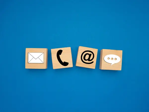 Mavi arka planda telefon, e-posta ve konuşma baloncuğu sembolleri olan tahta küpler. Üst Manzara. Müşteri hizmetleri ve bizimle iletişim kurma kavramı