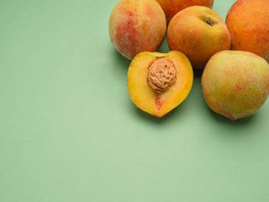 Yeşil arka planda bir yığın taze şeftali meyvesi. Üst Manzara. Yakın plan fotoğraf. Mesaj için yer var. Sağlıklı gıda ve meyve kavramı