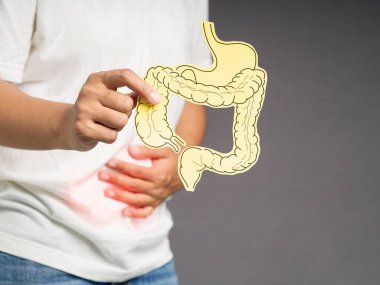 Elinde kağıttan yapılmış kalın bir bağırsak şekli mide ağrısı, mide ülseri, apandisit ya da mide sistemi hastalığından muzdarip.