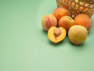 Yeşil arka planda bir yığın taze şeftali meyvesi. Üst Manzara. Yakın plan fotoğraf. Mesaj için yer var. Sağlıklı gıda ve meyve kavramı