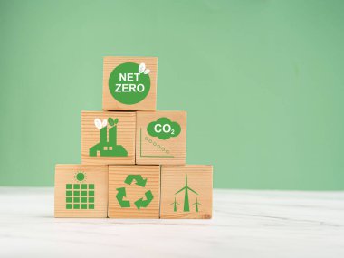 2050 'de ağ-sıfır emisyonları. Dünya Günü konsepti. Dünyayı, çevreyi ve karbonu koru. Yeşil arka planda mermer zeminin üzerinde çevre dostu ikonlar olan ahşap küpler.