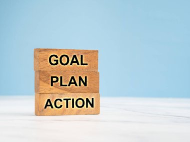 İş planı ve strateji konsepti. Ahşap bloklar, mavi arka planlı mermer zemin üzerinde Goal, Plan ve Eylem harfleriyle. Metin için boşluk