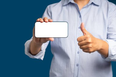 Boş beyaz ekranlı, yatay bir cep telefonu tutan ve mavi arka planda dururken başparmaklarını gösteren bir el. Müşteri geribildirimi, hizmet değerlendirmesi, deneyim ve tatmin kavramı