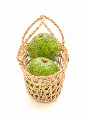 Beyaz arka planda bir sepet avokado. Yan görüş. Mesaj için yer var. Sağlıklı meyve kavramı