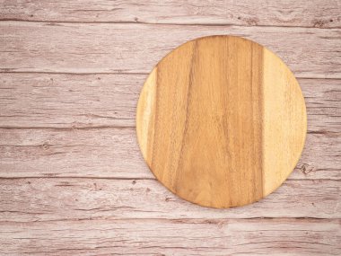 Tahta bir masanın üzerindeki boş tahta kesme tahtasının üst görüntüsü. Metin için boşluk