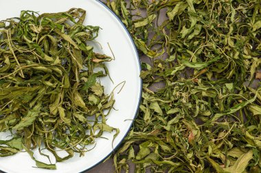 Kuru kenevir yaprağı çayının en üst görüntüsü. Dokulu marihuana yaprakları. Kenevir otlu içecek kavramı