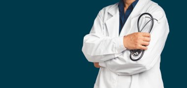 Kaliteli tıbbi hizmetler. Kolları mavi arka planda çapraz duran steteskop tutan üniformalı bir doktorun orta kısmı. Mesaj için yer var. Tıbbi personel, tıp ve bilim konsepti