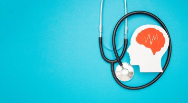 Kağıttan yapılmış bir beyin şekli ve açık mavi arkaplanda steteskop. Alzheimer, Parkinson, bunama, felç, nöbet ya da akıl sağlığı. Nöroloji ve Psikoloji