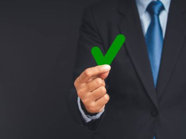 Oy kullanma hakkını kullanma kampanyası. Seçimlerde yeşil işaret işareti taşıyan bir işadamı gri bir arkaplanda duruyor. Özgürlük demokrasi kavramı