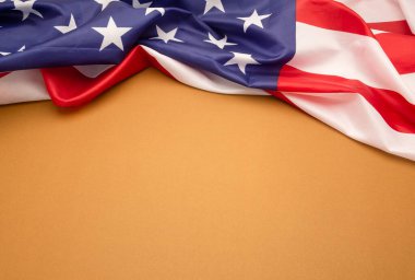 Kahverengi arkaplanda Amerikan bayrağının üst görüntüsü ve metin için kopya alanı. Yakın plan fotoğraf.