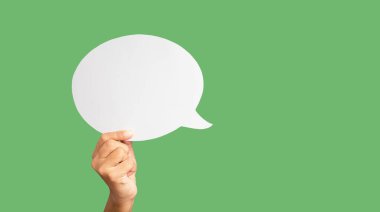 Stüdyonun yeşil arka planına karşı yeşil bir konuşma balonunu tutan yakın plan. Yakın plan fotoğraf. Metin için boşluk