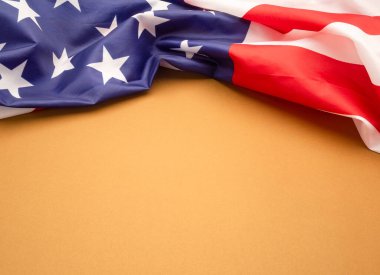 Kahverengi arkaplanda Amerikan bayrağının üst görüntüsü ve metin için kopya alanı. Yakın plan fotoğraf.