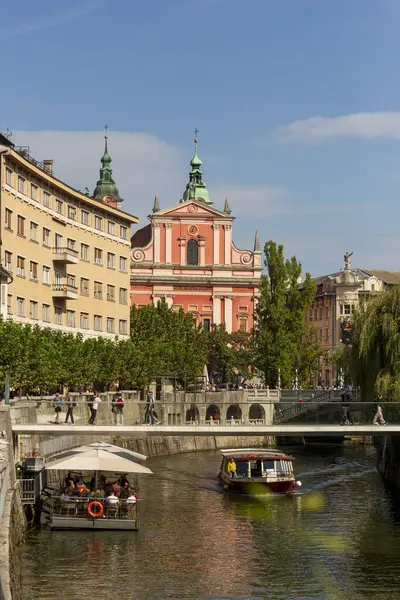 Ljubljanas 'ın ünlü pembe Fransisken Kilisesi' nin tarihi binalar ve yemyeşil alanlarla çevrili güzel manzarası. Ljubljana, Slovenya, 2024 Sonbaharı